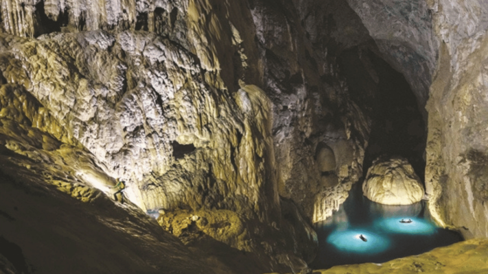 Tourists climb over the wall of Vietnam in Son Doong Cave